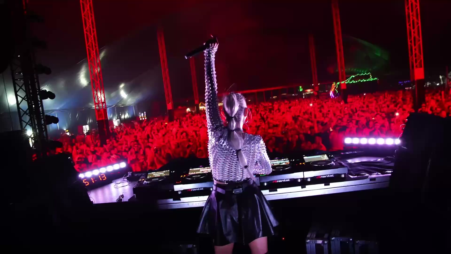CANDICE za DJským pultem před publikem a klubovým pódiem.